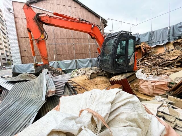 解体したトタンをつかむ重機